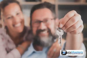 Image of a man and woman holding house keys and smiling